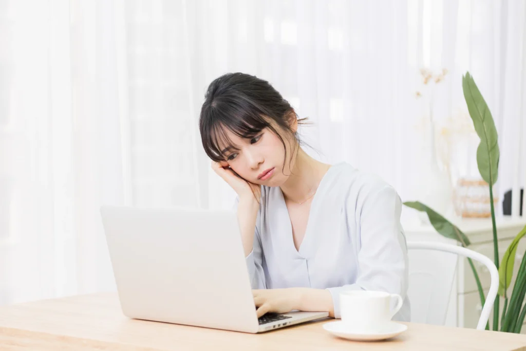 ChromebookでWordを使えず困っている女性がノートPCの前で悩んでいる様子